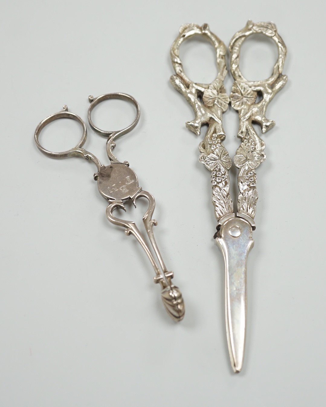 A pair of Victorian silver grape scissors, TS?, London, 1879, 17cm and a pair of Georgian silver sugar nips by Simeone Coley?